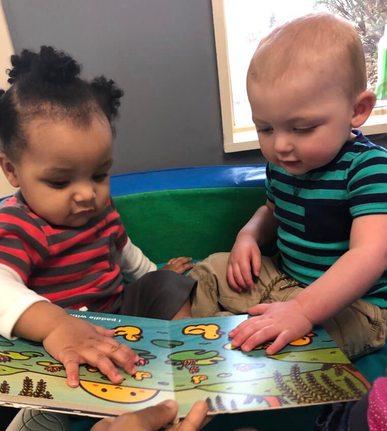 Infants are considering a book at Infants class, at Mt. Elizabeth Academy, Daycare, preschool, Kennesaw Christian school, private school
