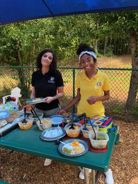 2 teachers serving lunch at a celebration outside